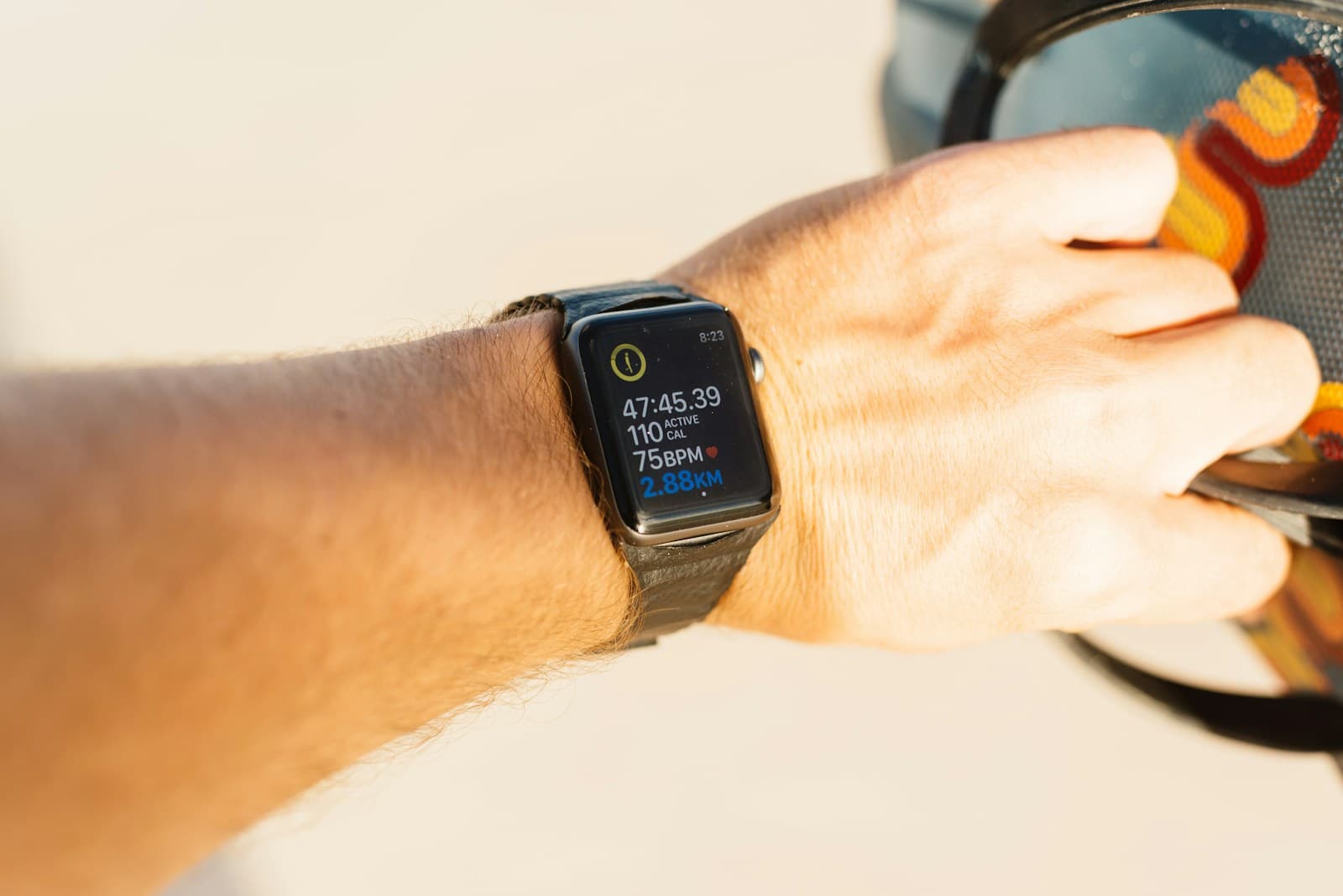 A smartwatch on a wrist displaying workout duration, heart rate, and distance.